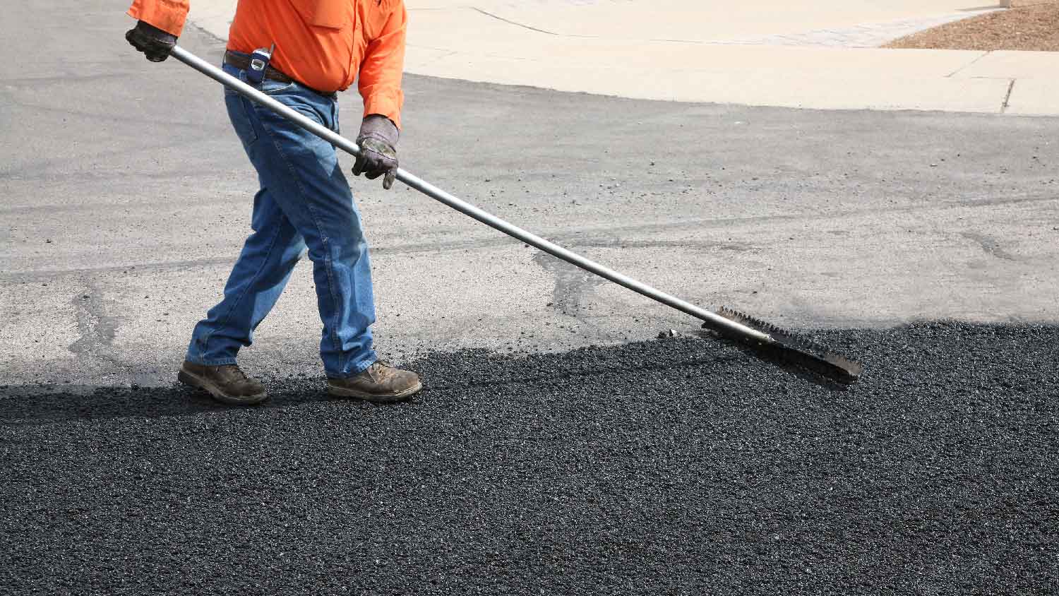 A worker laying asphalt