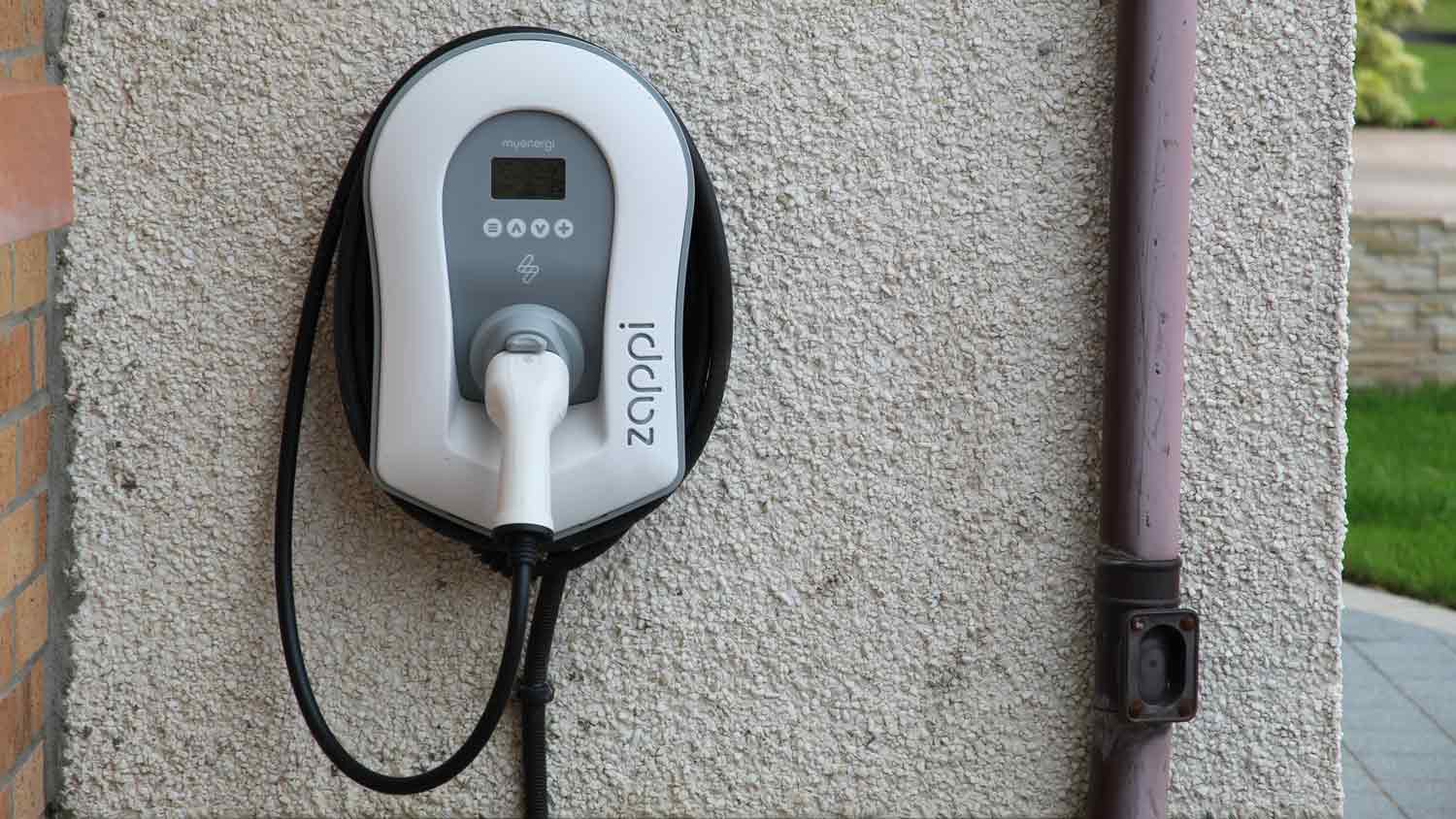 electric vehicle battery charger on wall outside home