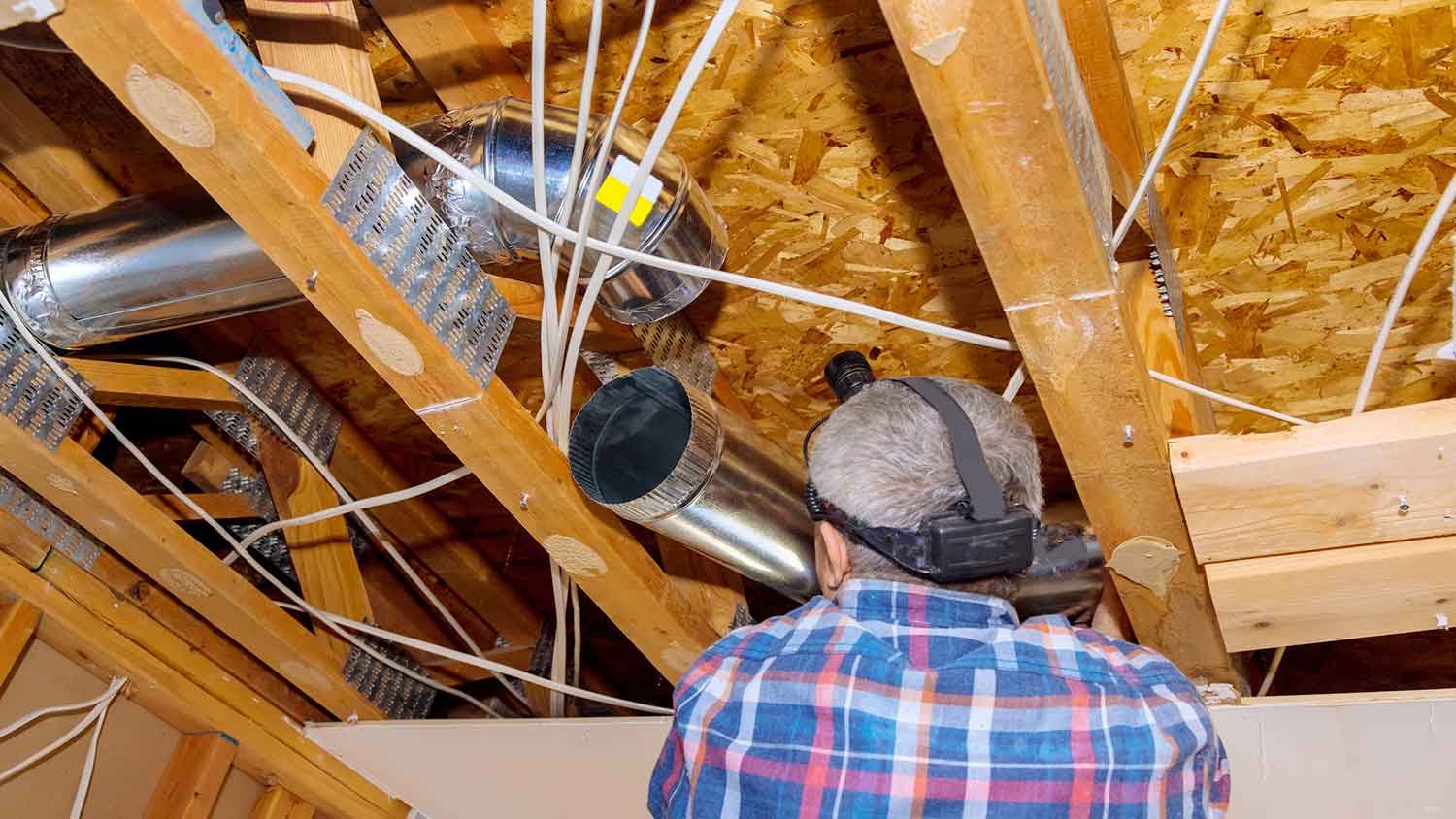 Contractor installing air duct in a house