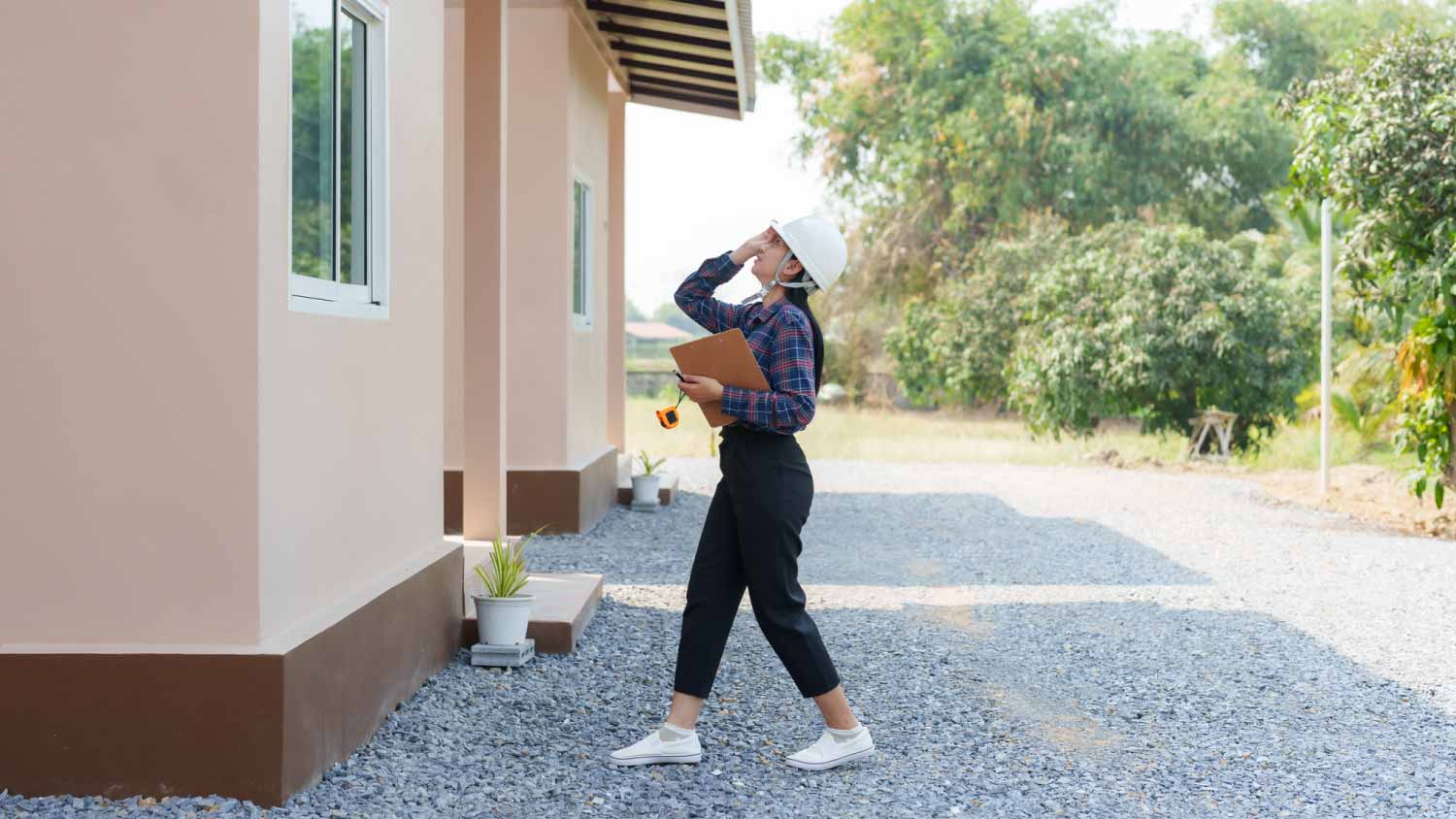 Building inspector walking along house
