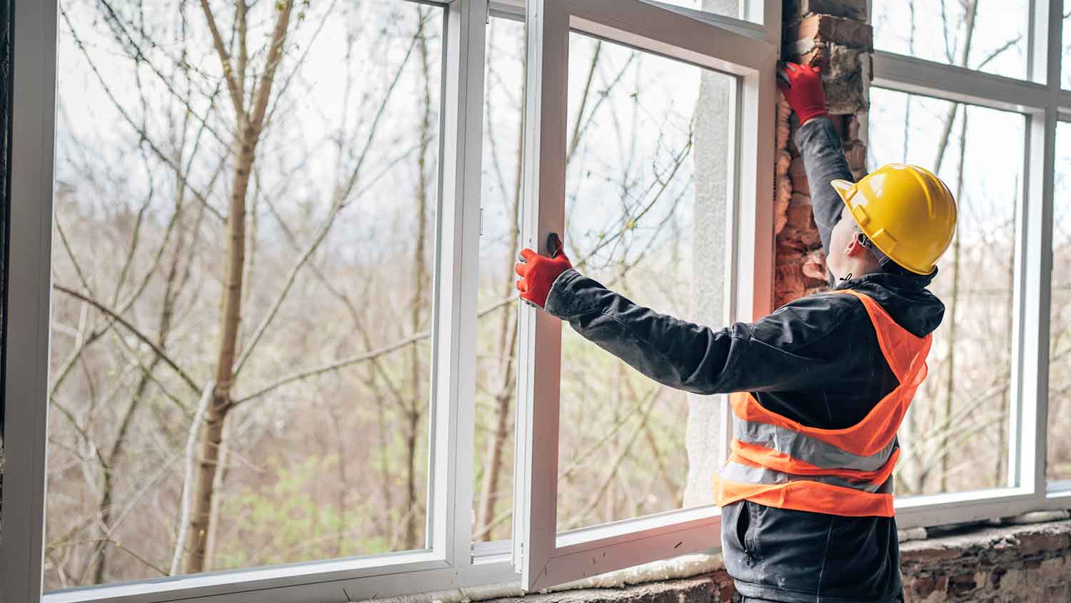 Contractor wearing a helmet installing a new window