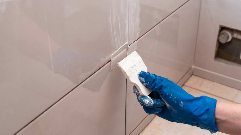 pushing grout into wall tile joints