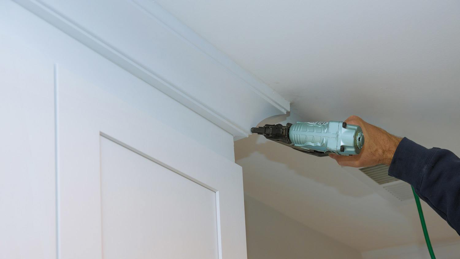 carpenter drilling crown molding