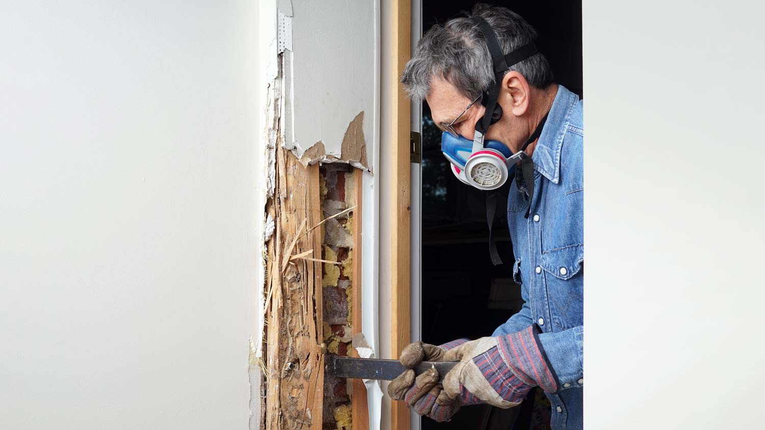 man removing termite damaged wood