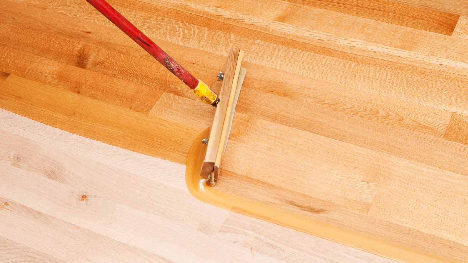 A professional sanding a wood floor