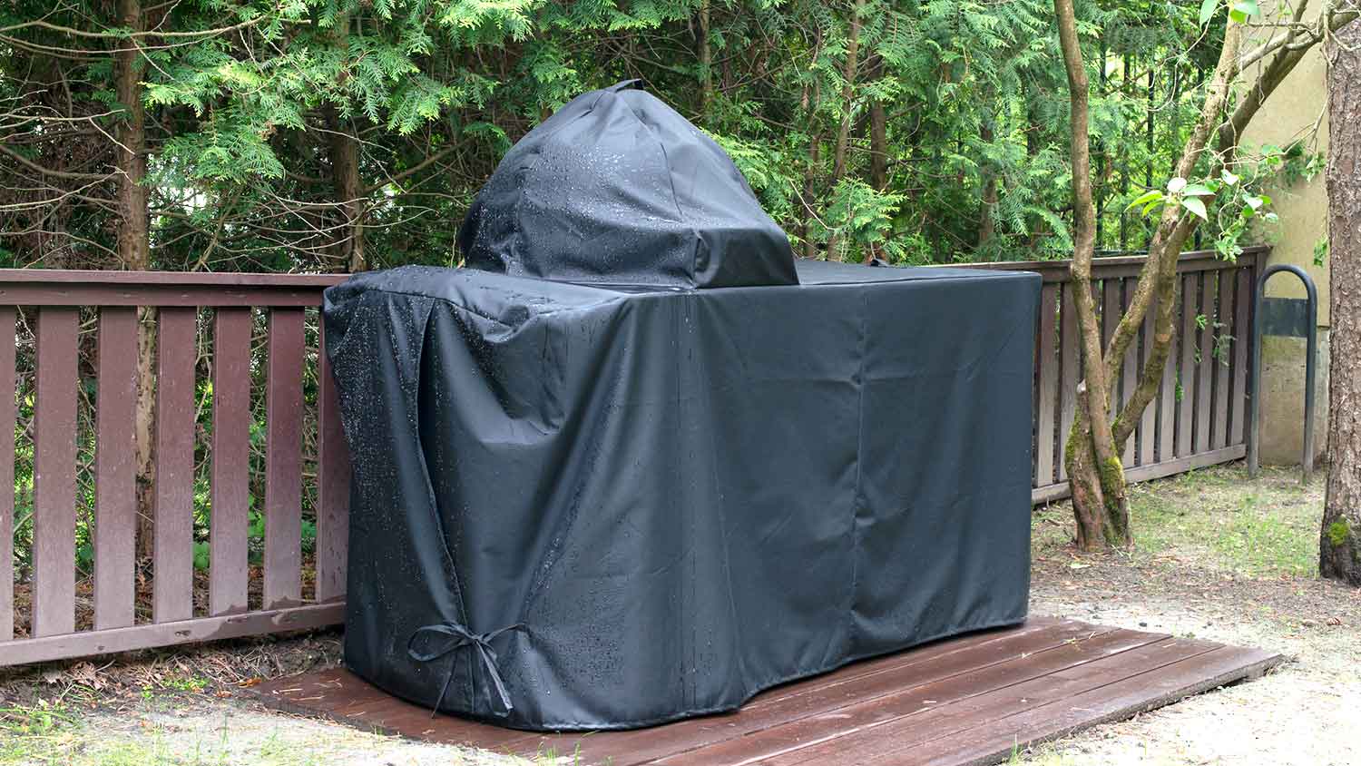 BBQ grill with a waterproof cover sitting on the patio