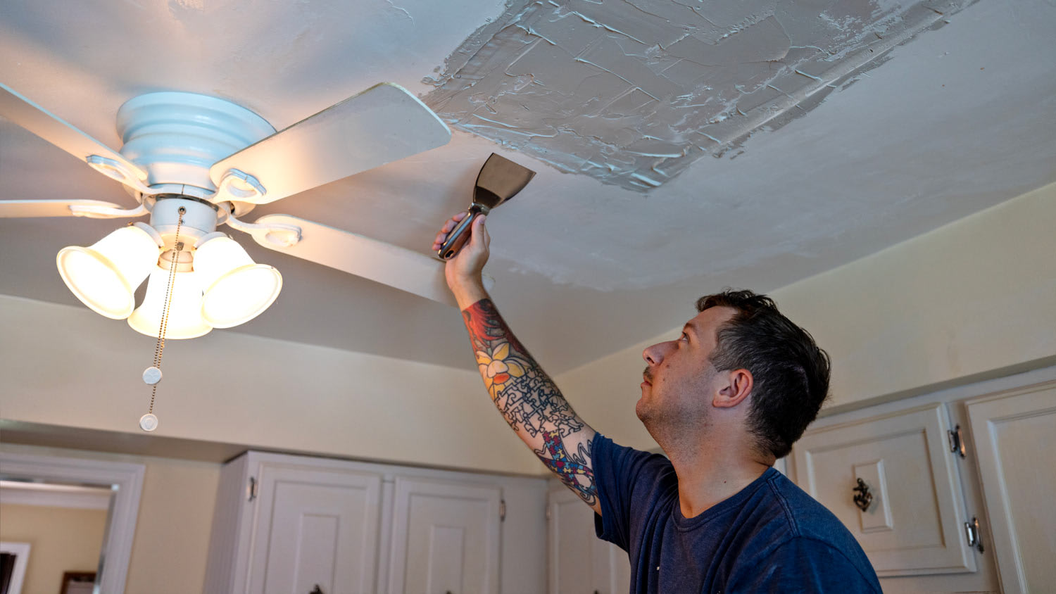 A man putting plaster on the ceiling
