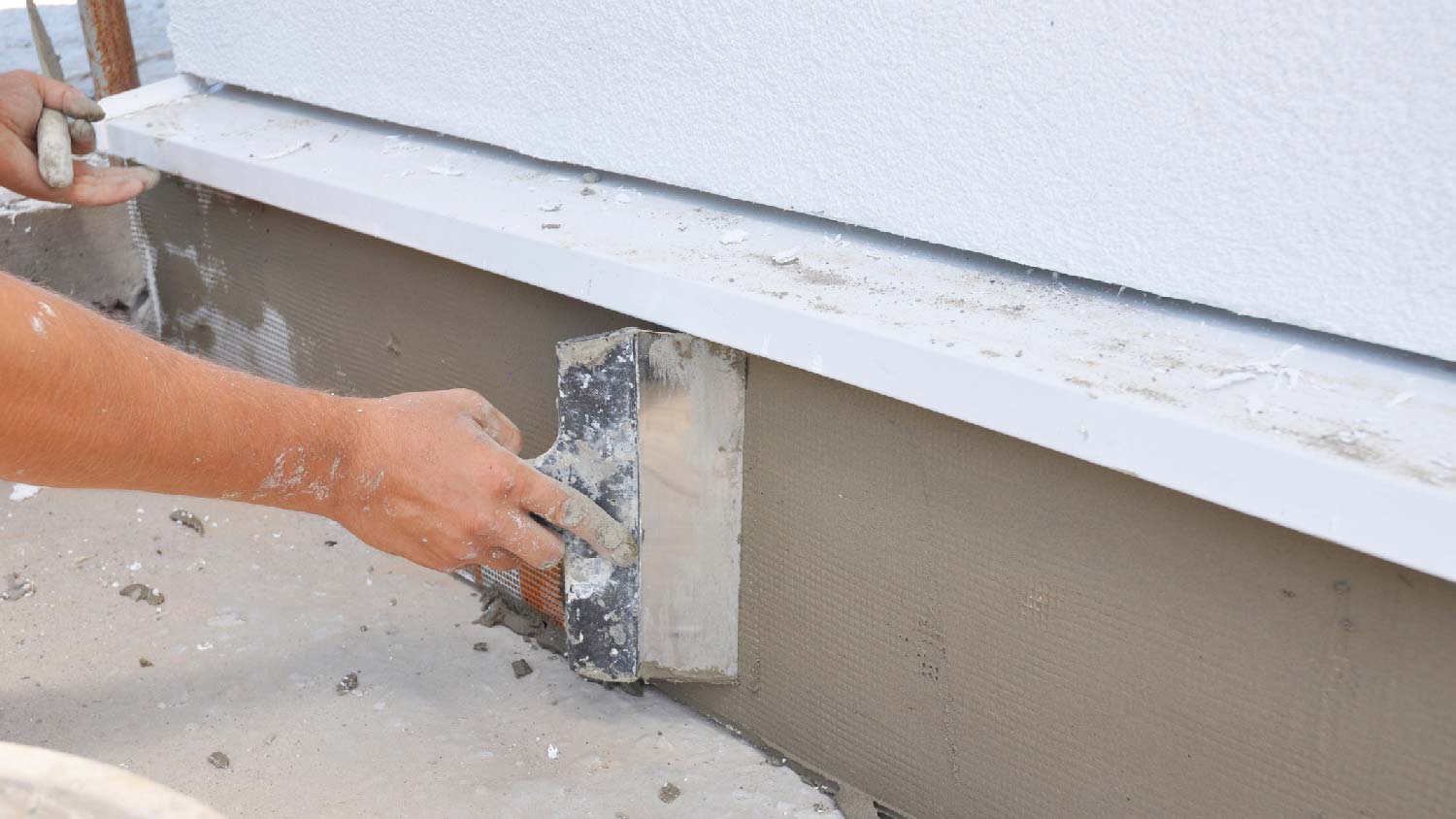 A person parging a wall
