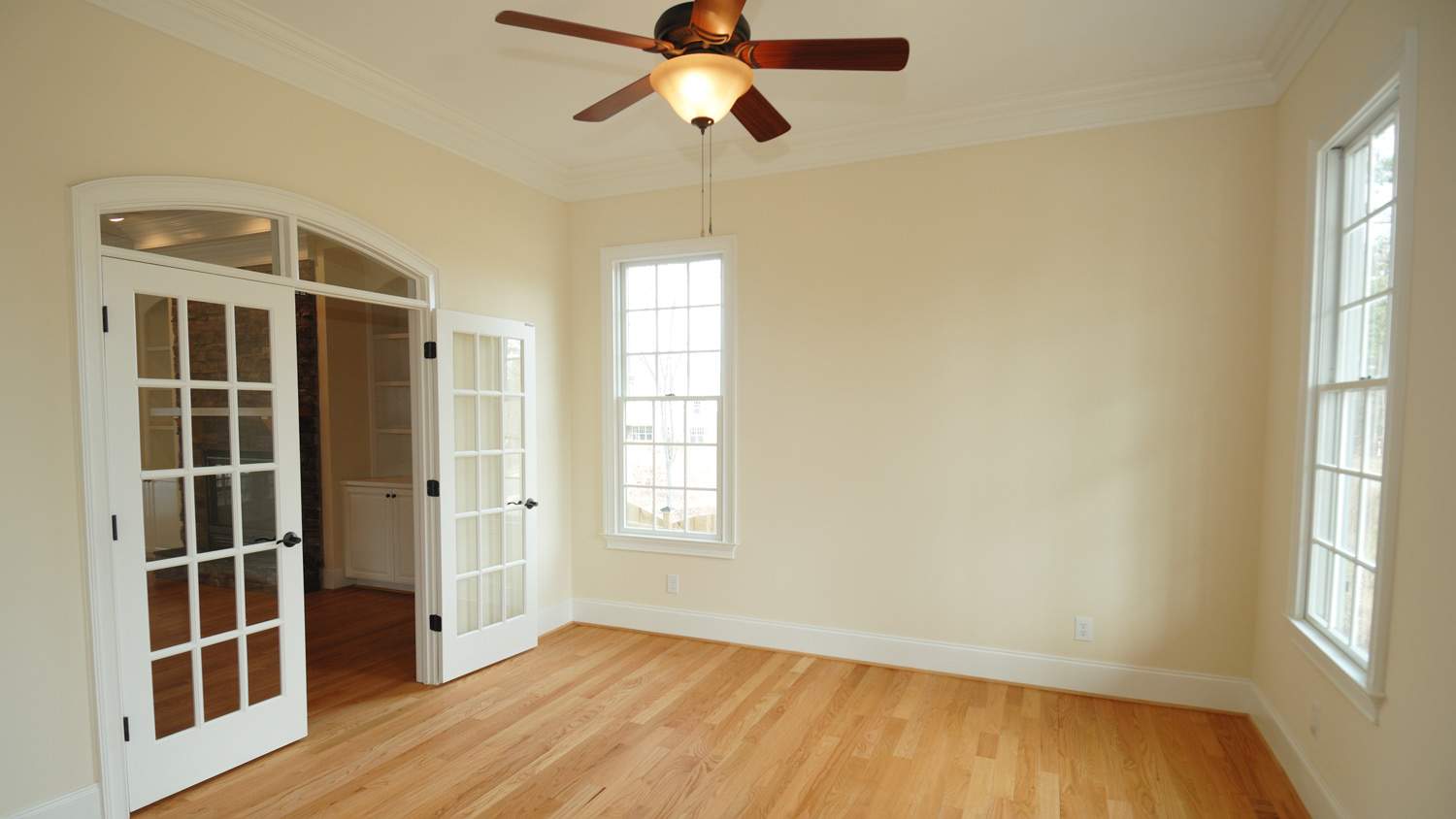 View of an empty room showing a roof fan and open door