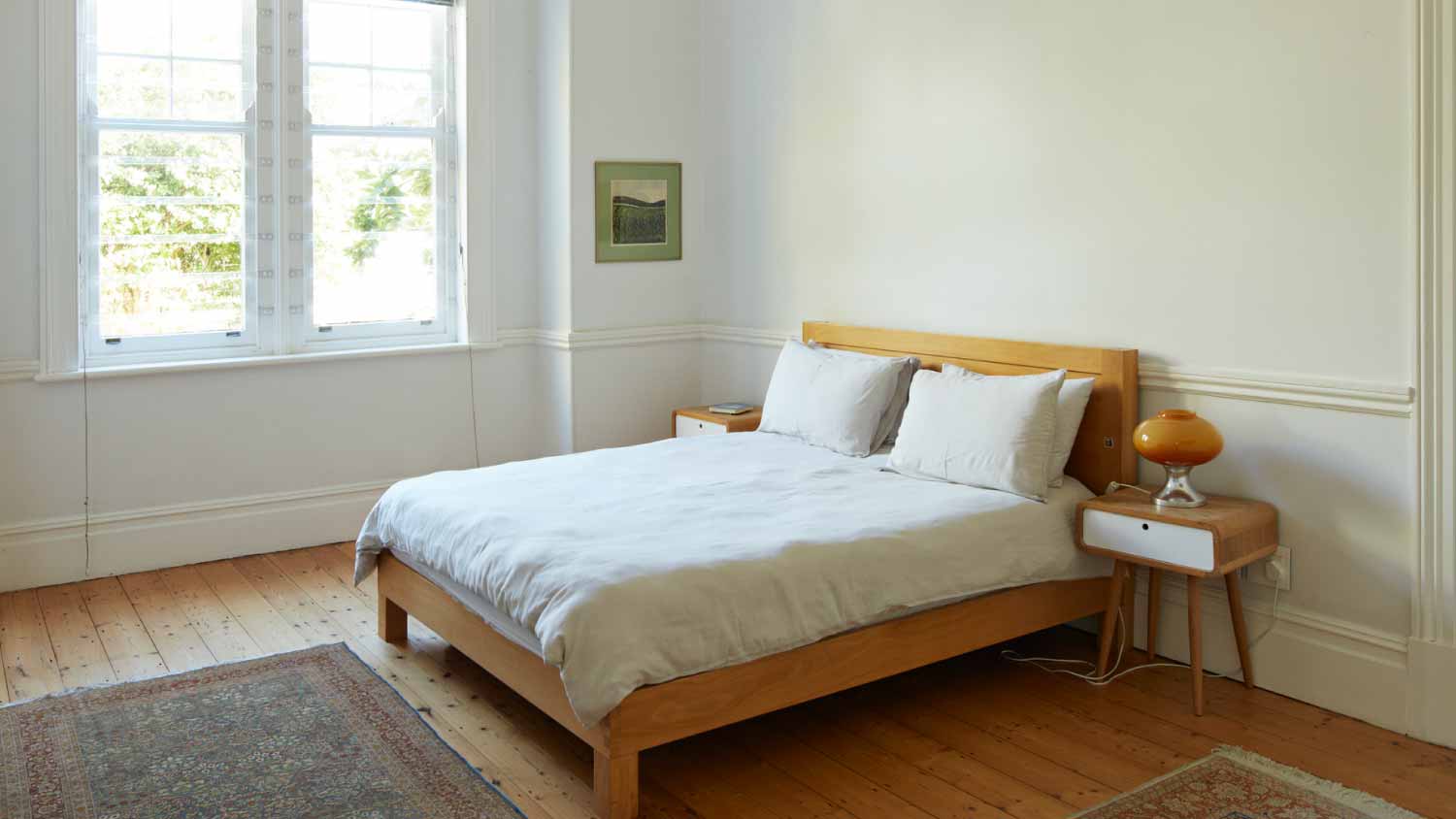Wooden bed by window in bedroom