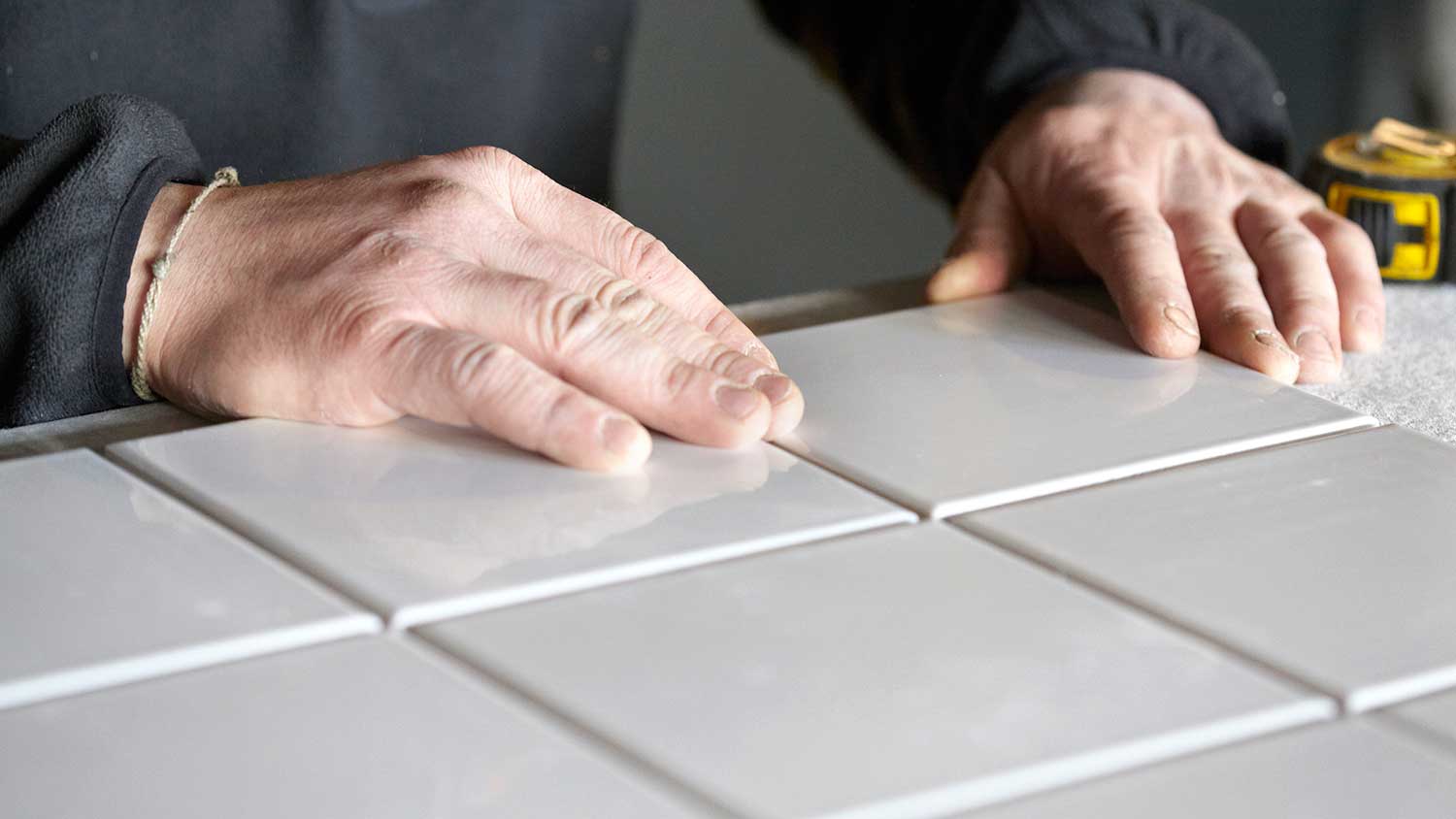 Handyperson tiling a kitchen countertop