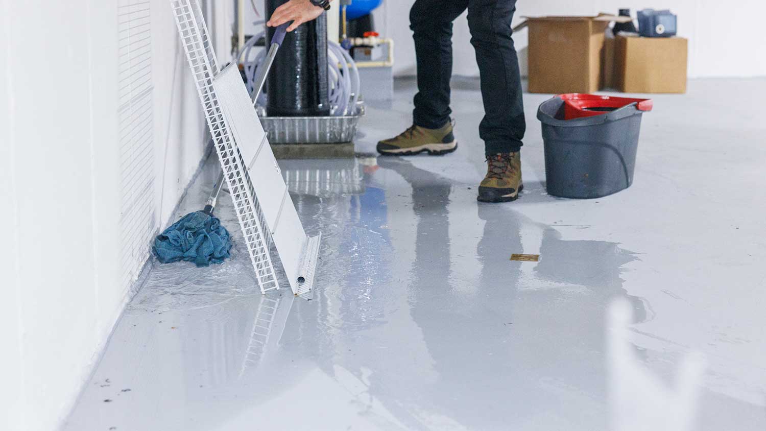 Person using a mop to remove water from the basement
