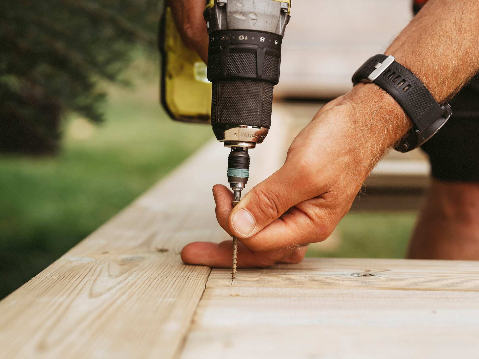 Worker using power to install a floorboard