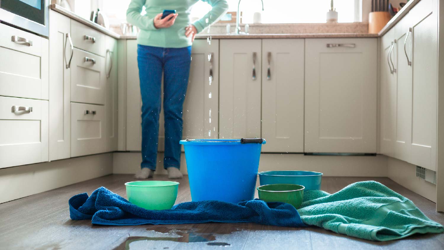 Buckets and pots catching flowing water from the ceiling