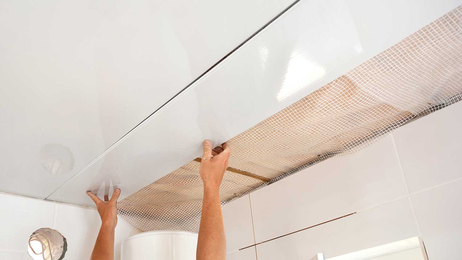 Worker installing PVC ceiling panels