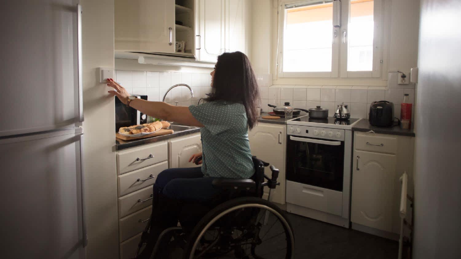 A woman in a wheelchair prepping her meal