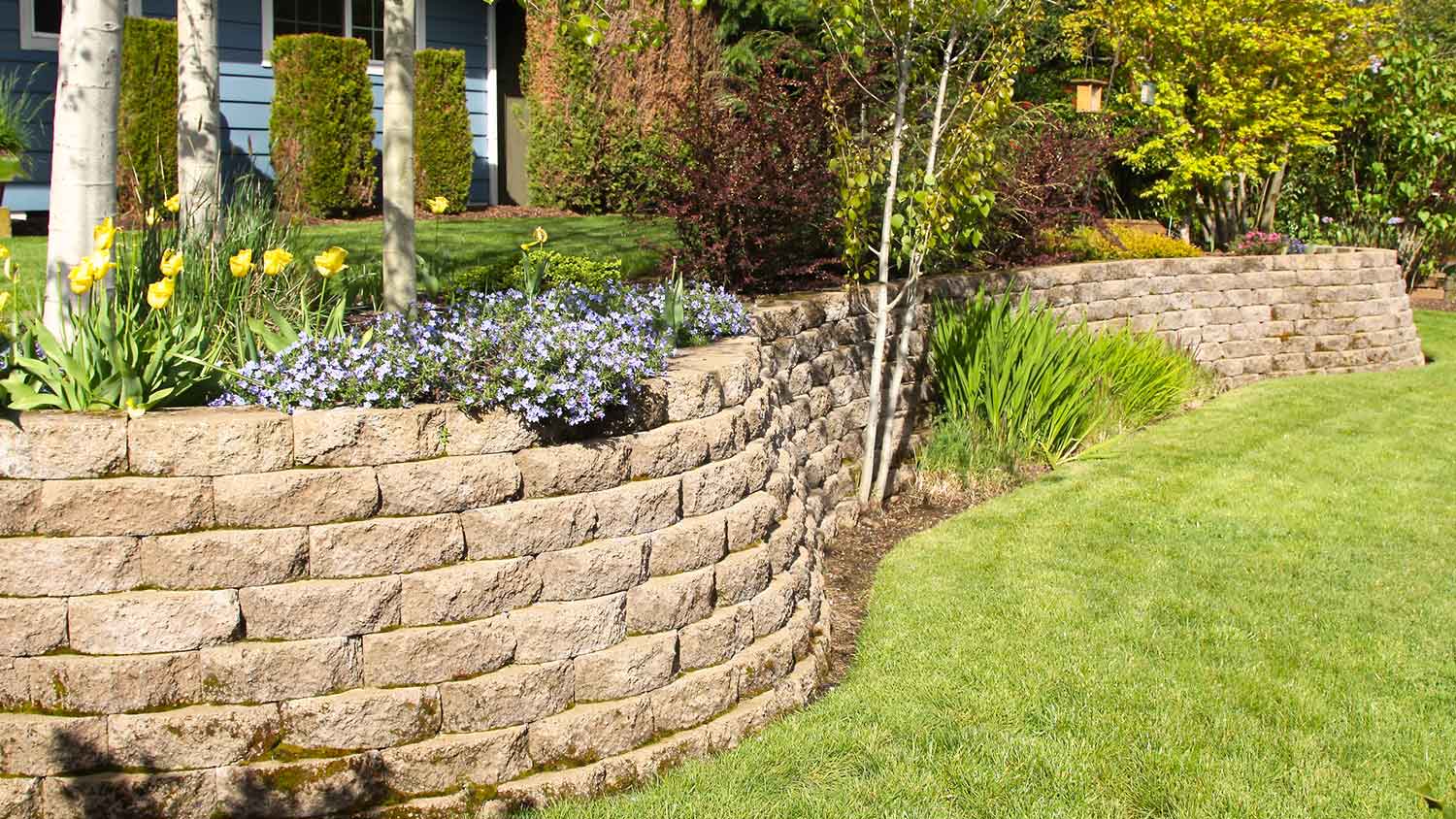 cobblestone retaining wall in a landscaped yard