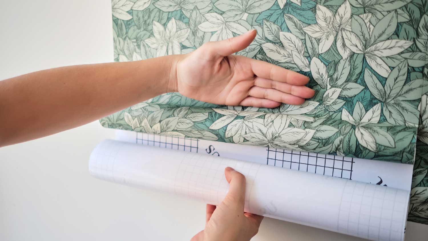 A woman installing a vinyl wallpaper
