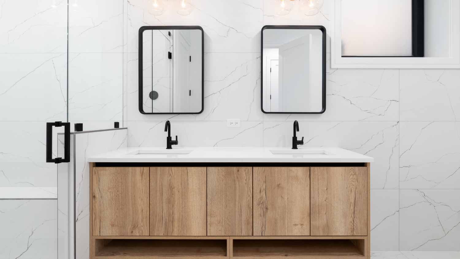 Bathroom with marble walls and floating wood cabinet