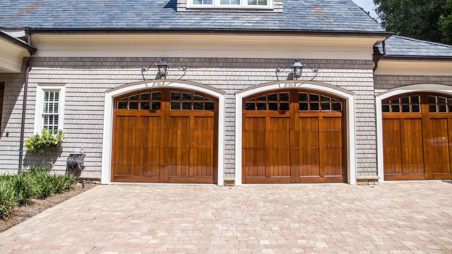 Driveway with pavers and wooden garage doors
