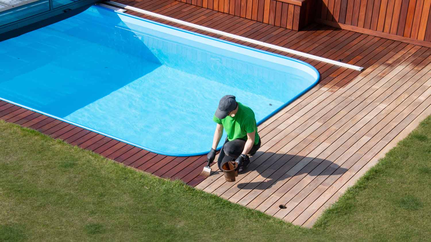 A worker painting a pool deck