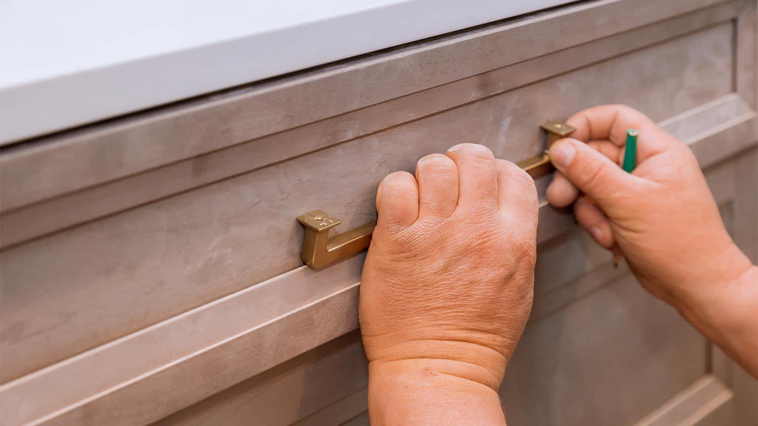 man installing bathroom drawer handle