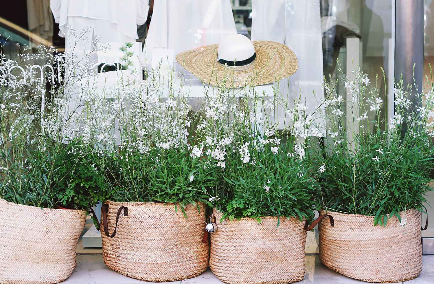 Wicker basket planters outside of a boutique