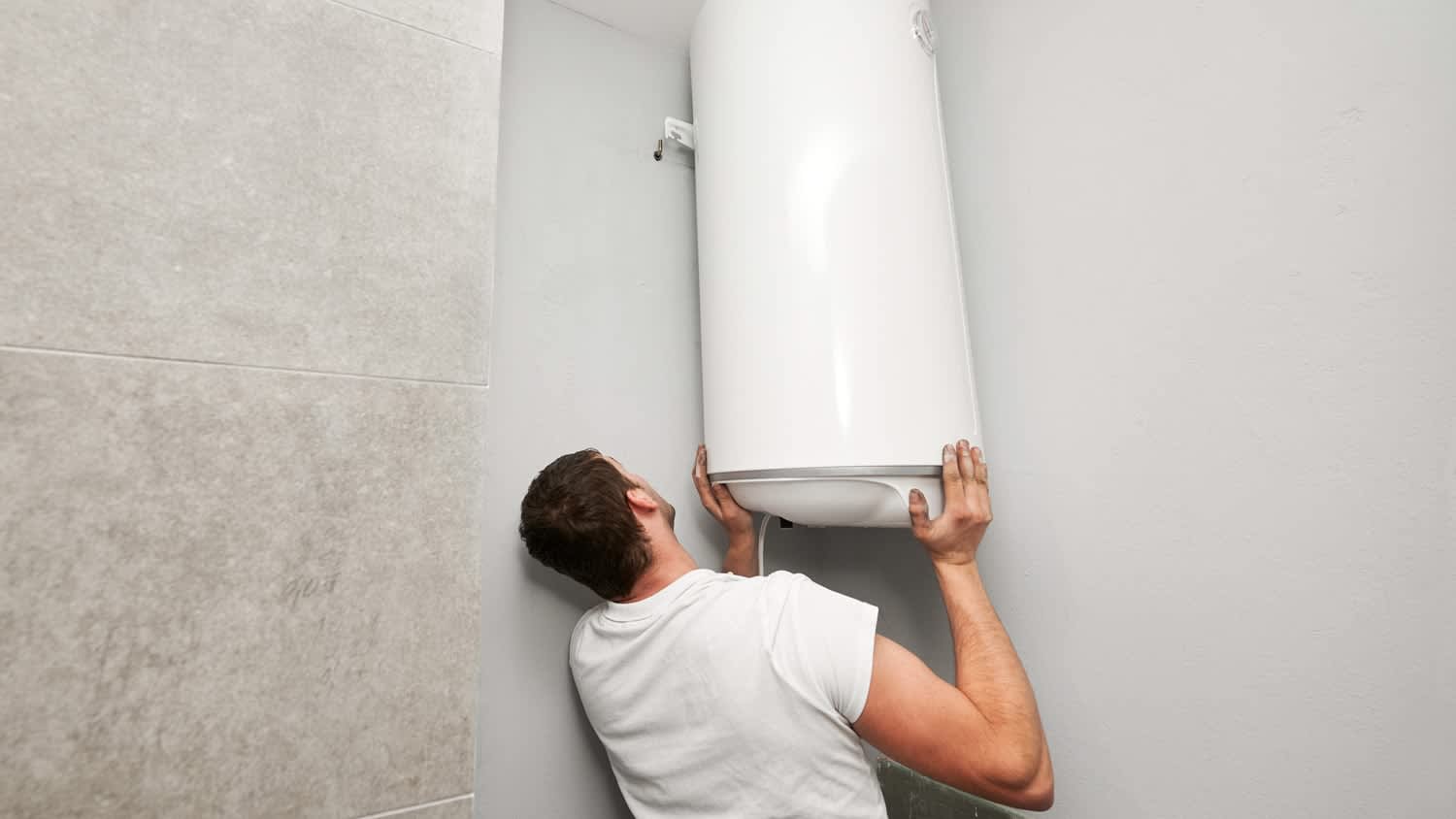 Man installing boiler water heater in apartment
