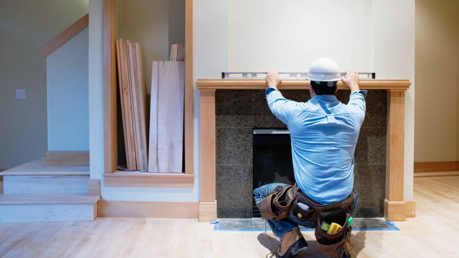 Worker using level across top of a fireplace