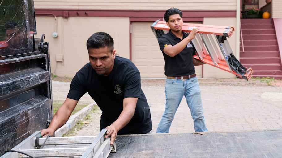 Painters loading ladders in van.