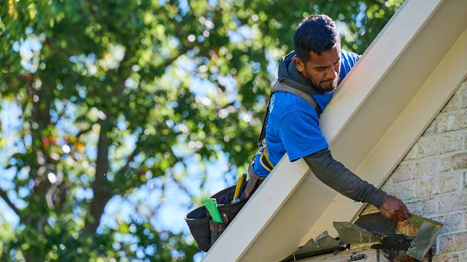 Roofer removing old shingles.