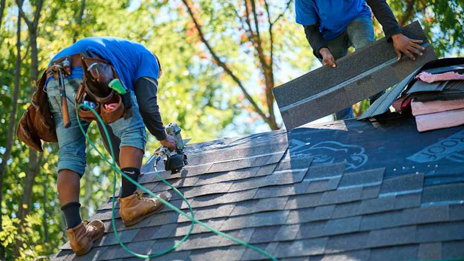 Men applying shingles to rooftop.