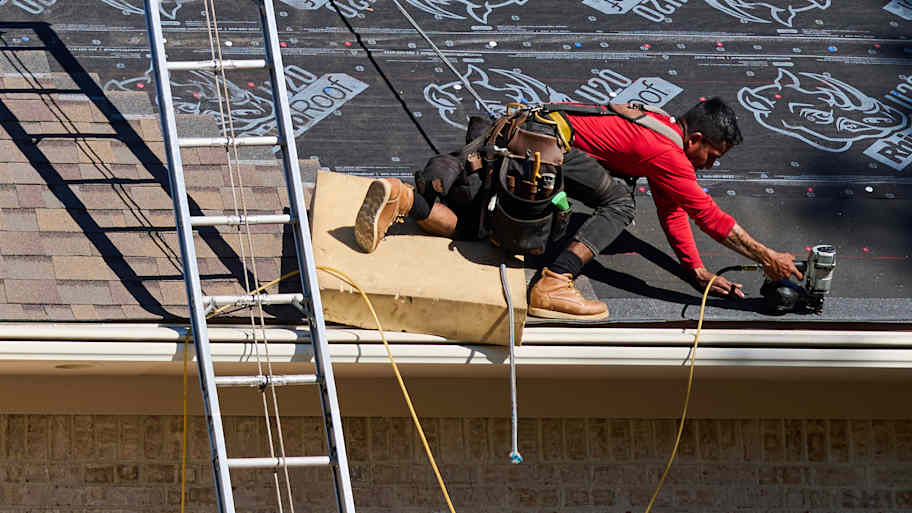 Man in red shirt repairing roof