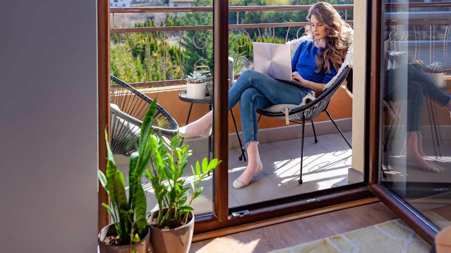 Woman working on computer on balcony