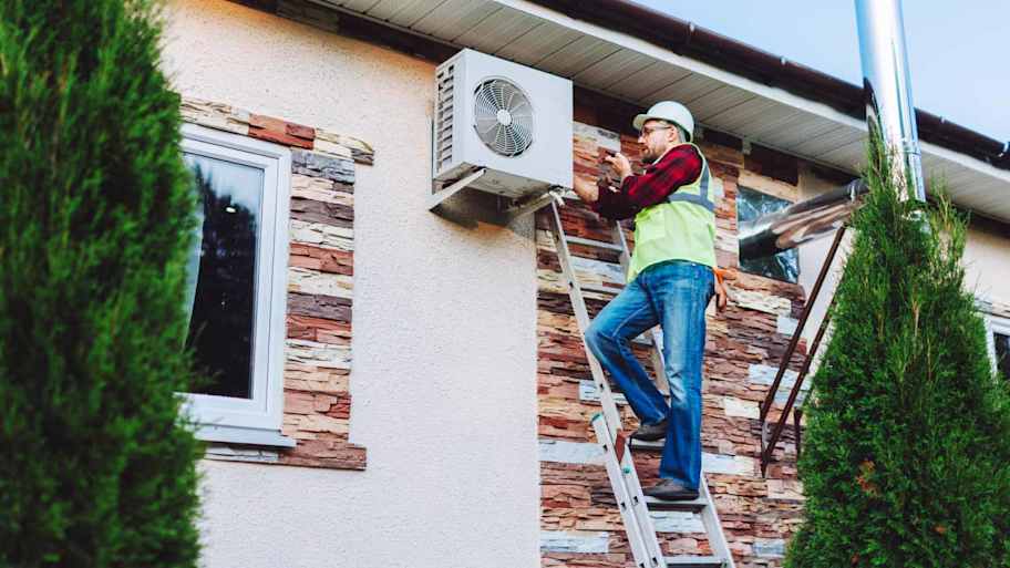 Worker repairing heat pump