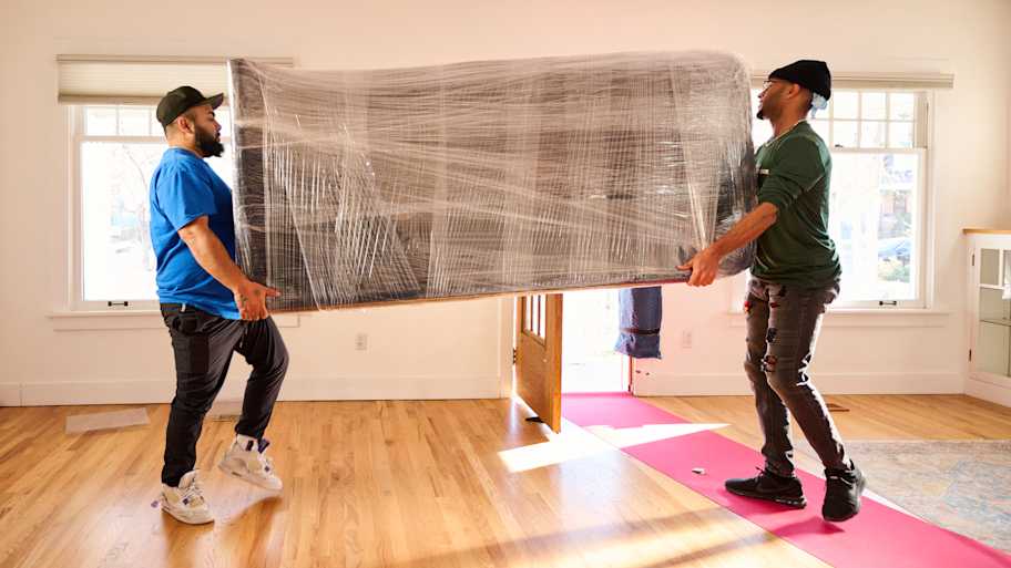 Men moving large piece of furniture.