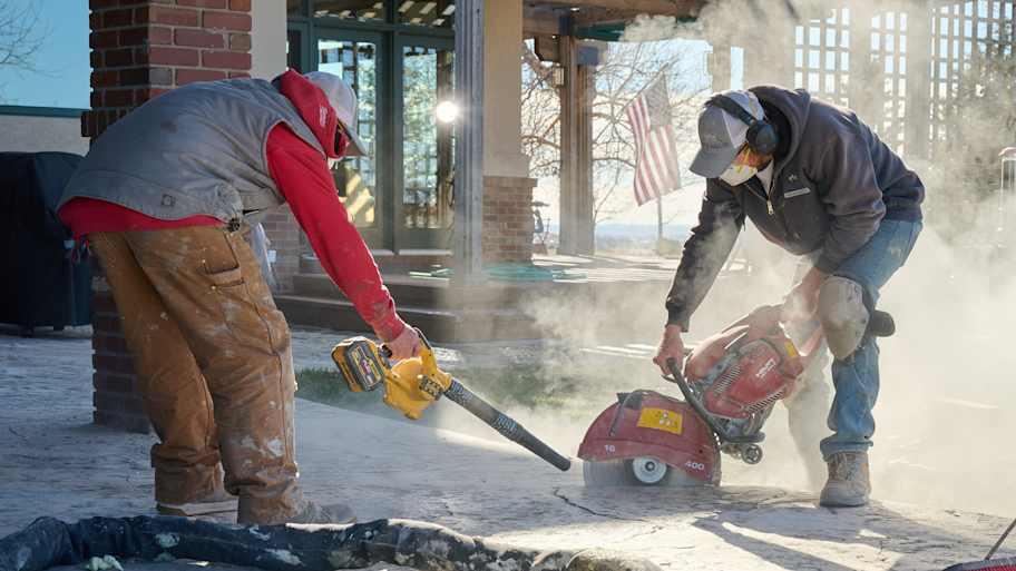 Tow men cutting into concrete. 