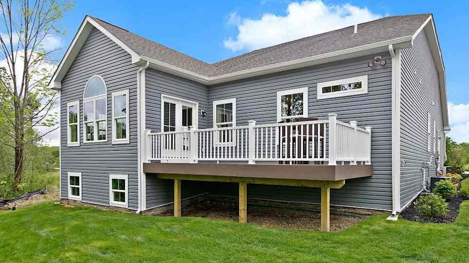 Raised backyard deck with white vinyl railing 