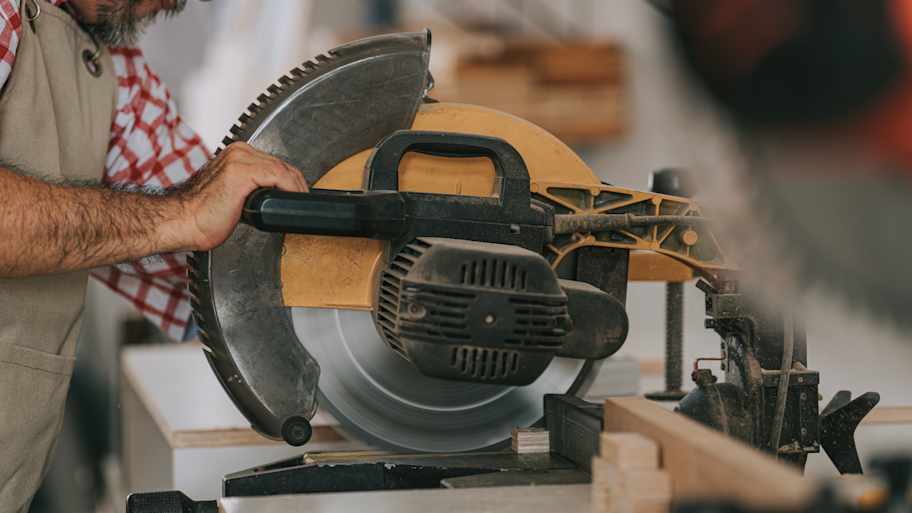 A man operating a miter saw 