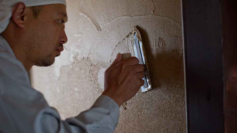 A man applying plaster to a wall