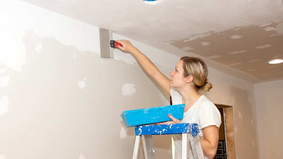 Woman applying joint compound 