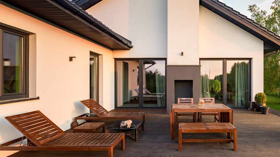 A wooden deck in the backyard of a house