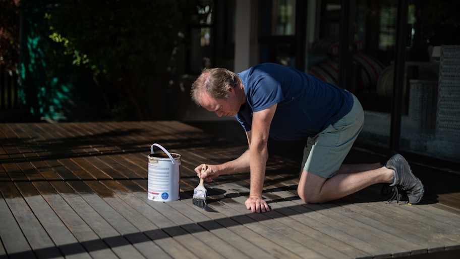  A man staining deck boards 