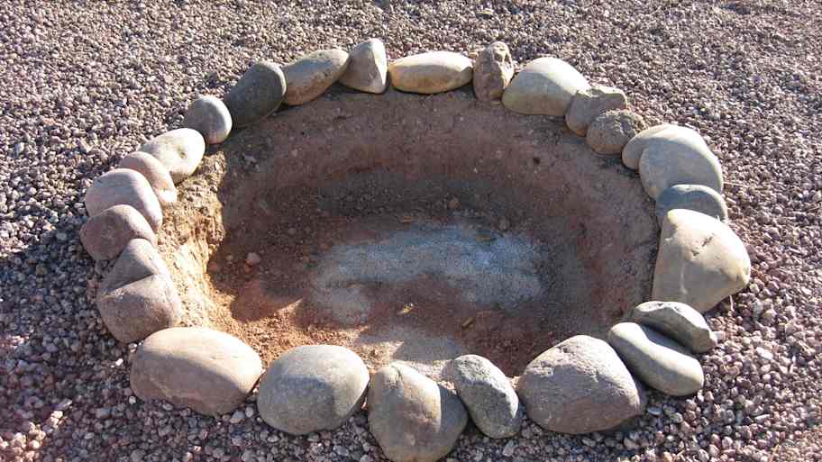 Empty fire pit surrounded by gravel