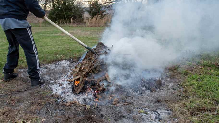 Person managing a fire pit in the yard