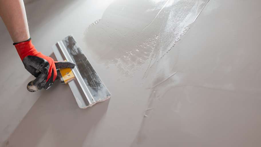 Close-up of a spatula working on drywall