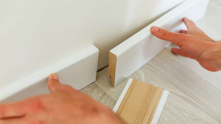 A person connecting two baseboards