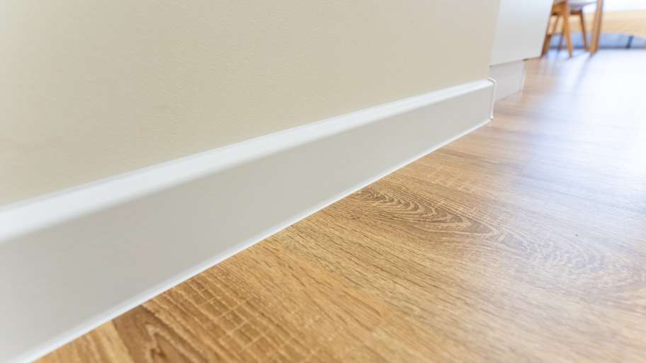Wooden floor with white baseboard