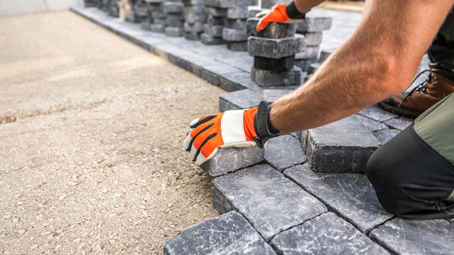 Worker laying paving stones