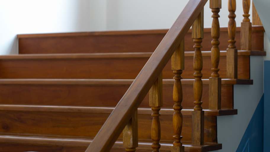wooden staircase with a polished handrail